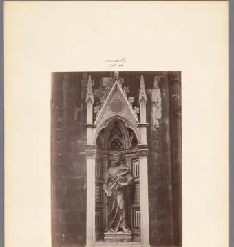 Saint Peter sculpture standing in a Gothic niche, holding a book.