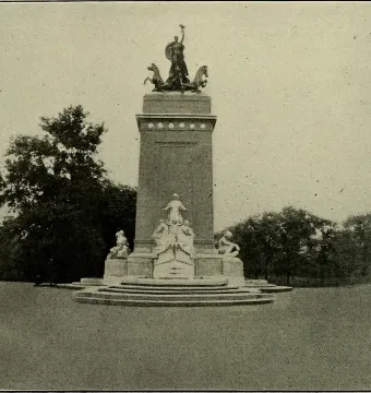 The USS Maine National Monument with sculpted figures and rearing horses on a multi-tiered pedestal in a grassy setting.