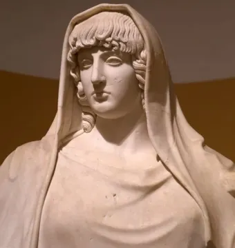 Upper torso of the Giustiniani Hestia marble statue, showing a veiled female figure with wavy hair and draped folds across the chest.