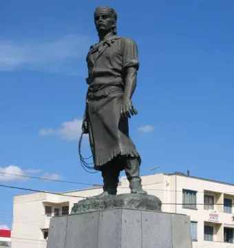 Laçador statue of a gaucho standing on a stone pedestal with a lasso in hand.