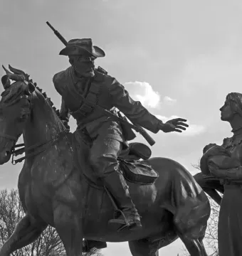 National Women’s Monument statue group showing a man on horseback reaching toward a woman holding a baby.