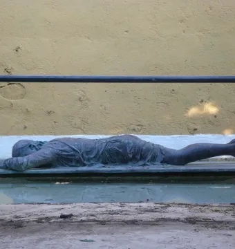 Ophelia Drowned sculpture lying on a platform in a shallow pool of water