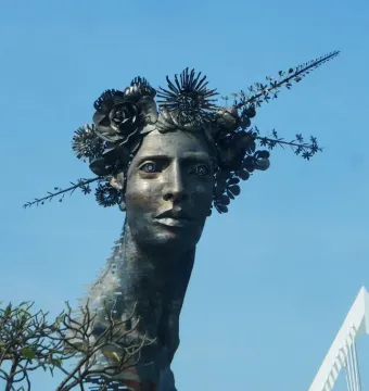 Reminiscencia, a metallic bust with an elongated neck and an ornate crown of metal flowers and spiky foliage.