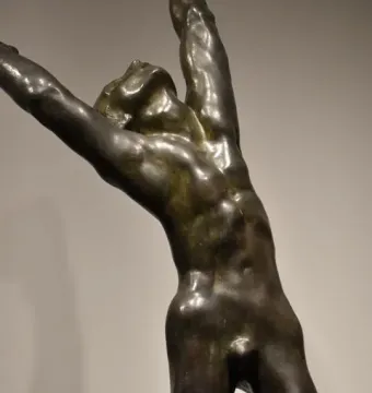 The Prodigal Son bronze sculpture showing a muscular nude male figure with arms raised and head thrown back.