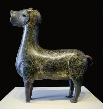 Stylized metallic deer sculpture from Madinat al Zahra on a white pedestal.