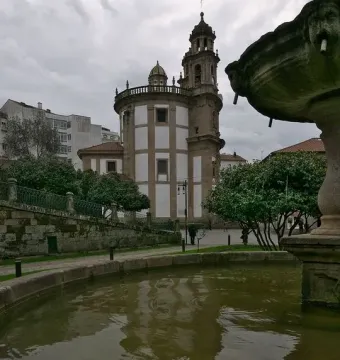 Herrería Fountain with a reflection of the Virgen Peregrina church in dark water