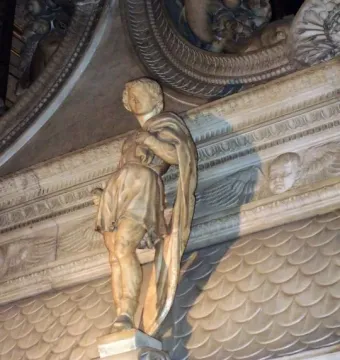 Saint Proculus marble statue in flowing robes against an ornate carved marble backdrop.
