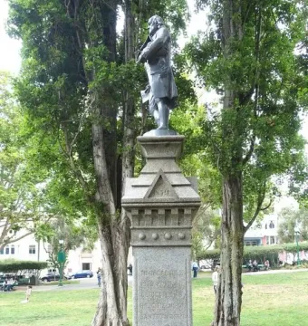 Benjamin Franklin Memorial statue on a tall stone pedestal in a grassy park