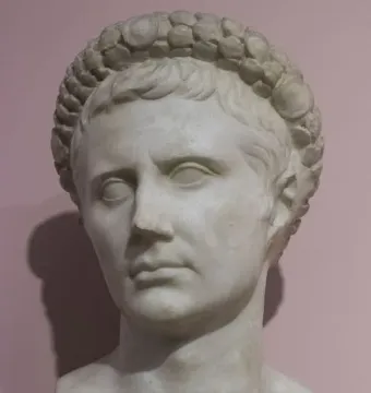 Bust of Augustus with a gemmed crown on a pink background.