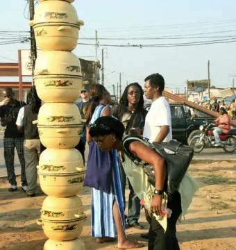Colonne Pascale, a tall pale yellow column made of stacked pots with decorative bands, standing on a reddish base outdoors.
