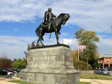 Custer equestrian statue on a stone pedestal with CUSTER carved on the front