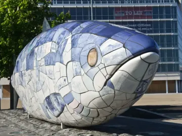The Big Fish sculpture covered in blue and white ceramic tiles with printed text and images.