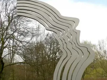 De Schreeuw sculpture with wavy metal strips forming a human profile in Oosterpark