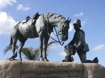 Horse Memorial sculpture showing a saddled horse beside a kneeling uniformed figure holding out a pail.