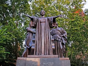 Alma Mater bronze statue with a central robed female figure and two flanking figures on a stone base