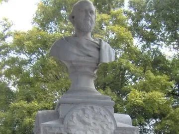 Beriah Magoffin Monument with a bust of a bearded man on a pedestal in a cemetery.