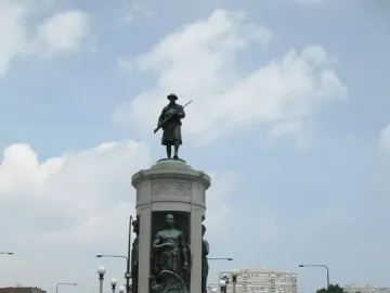 Victory Monument in Chicago, a tall multi-tiered monument topped by a soldier statue and set in a landscaped traffic circle.