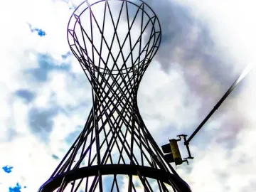 Mae West sculpture silhouetted against a bright cloudy sky with blue patches.