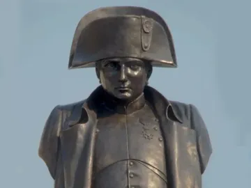 Bronze bust of Napoleon I in a bicorne hat on a plinth with bronze eagles.
