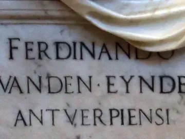 Close-up of the Tomb of Ferdinand van den Eynde showing engraved marble inscription and part of a draped sculptural element.