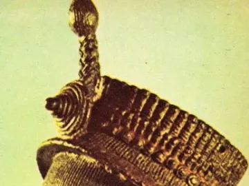 Bronze Head from Ife shown in profile, with finely detailed facial striations and an elaborate textured crown.