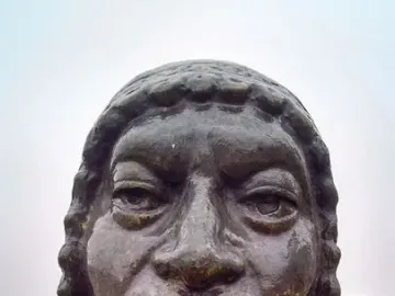 Close-up of La Yunta bronze statue showing the head and upper chest with a weathered surface.