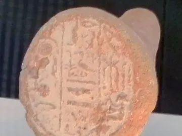 Merimose funerary cone with impressed hieroglyphs on a reddish-brown clay surface.
