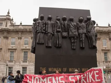 Monument to the Women of World War II with bronze figures of women in uniform and civilian clothing on a dark rectangular memorial.