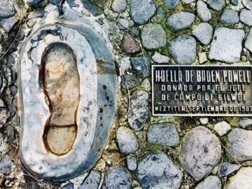 B-P\'s footprint set in a stone surface beside a dark plaque with Spanish text.