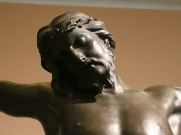 Close-up of Bernini\'s bronze Corpus showing the head and upper torso of Christ with closed eyes and a crown of thorns.