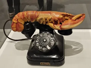 Salvador Dalí’s Lobster Telephone, showing a black rotary phone with a reddish-orange lobster on the cradle.