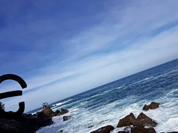 Peine del Viento steel sculptures on rocky coast with waves crashing nearby