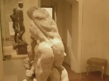 Michelangelo\'s Two Wrestlers sculpture showing two nude male figures grappling in a display case.