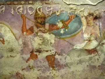 Detail of the Amazon Sarcophagus showing a bearded warrior facing a partially draped female figure on a faded painted surface.
