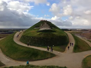 Northumberlandia grassy mound with walking paths and visitors near the summit