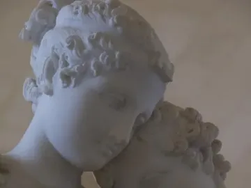 Close-up of Standing Psyche and Love showing two white marble figures, with one holding a small winged figure.