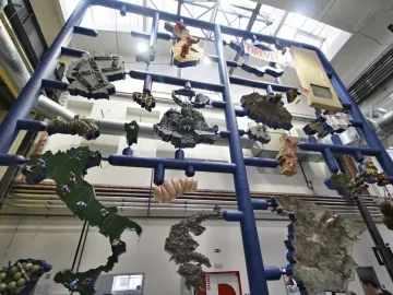 Entropa sculpture with a blue frame holding sculpted scenes, including football players and a castle.