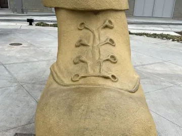Close-up of the Golden Driller\'s large tan boot with sculpted laces and a textured surface.