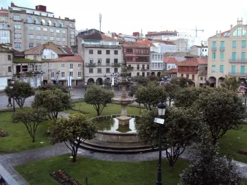 Herrería Fountain in a tree-lined park with surrounding buildings