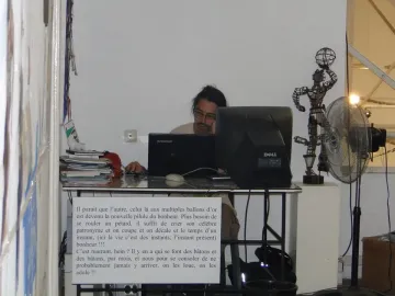 La Nouvelle Liberté sculpture standing on a white pedestal beside a computer monitor and standing fan