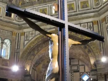 The Santa Croce Crucifix shows a large wooden Christ figure on a dark cross inside a grand church, with visitors gathered below looking up.