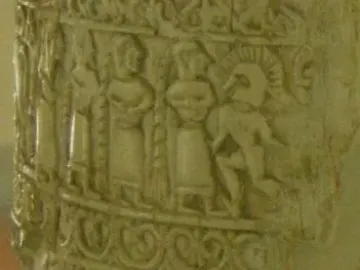 Detail of the Situla of the Pania showing a carved relief band with human figures, including a figure in a crested helmet.