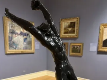 Rodin\'s The Prodigal Son sculpture showing a nude male figure kneeling with arms thrown upward in a museum gallery.