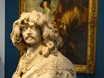 Marble bust of Thomas Baker with curly hair, mustache, and a pointed beard.