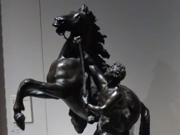 Marly Horses bronze sculpture of a rearing horse and a muscular man wrestling it with a staff.