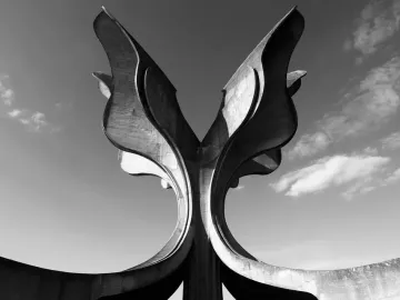 Stone Flower, a large concrete sculpture with curved petal-like forms rising against a cloudy sky.