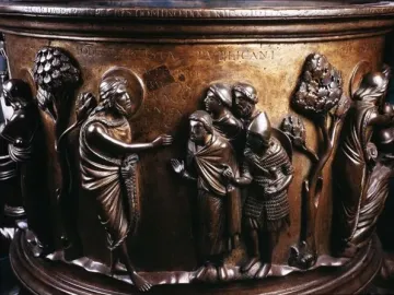 Detail of the Baptismal Font at St Bartholomew\'s Church showing a haloed figure addressing robed men in relief sculpture.