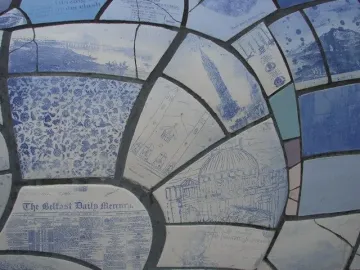 Close-up of the Big Fish sculpture’s blue and white mosaic scales with illustrations and text fragments