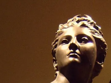 Close-up of Diana’s bronze head and upper torso, with a staff or spear visible beside her shoulder.
