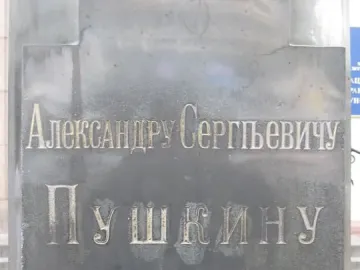 Weathered plaque with Cyrillic inscription for Pushkin and the dates 1799 and 26 May 1899.